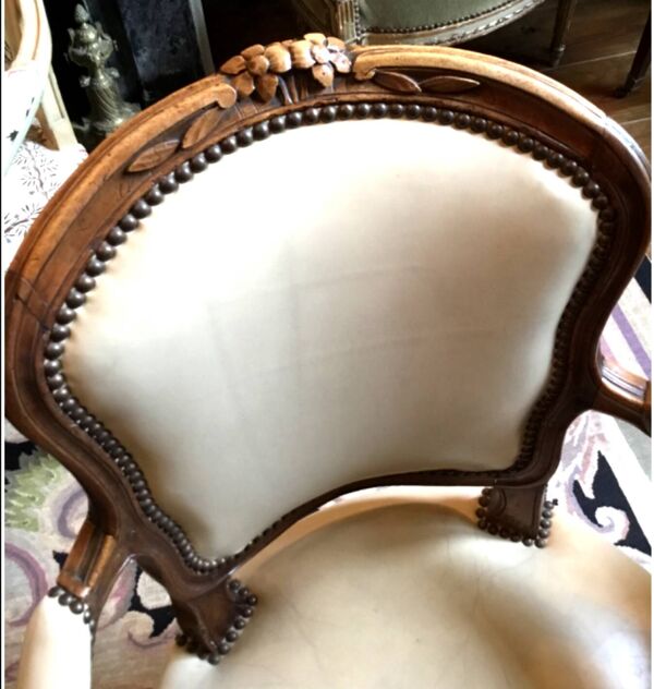 Fauteuil d’époque Louis XV en bois naturel à dossier cabriolet sculpté de fleurettes