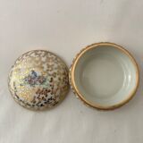 White and golden pill box with a blue bird