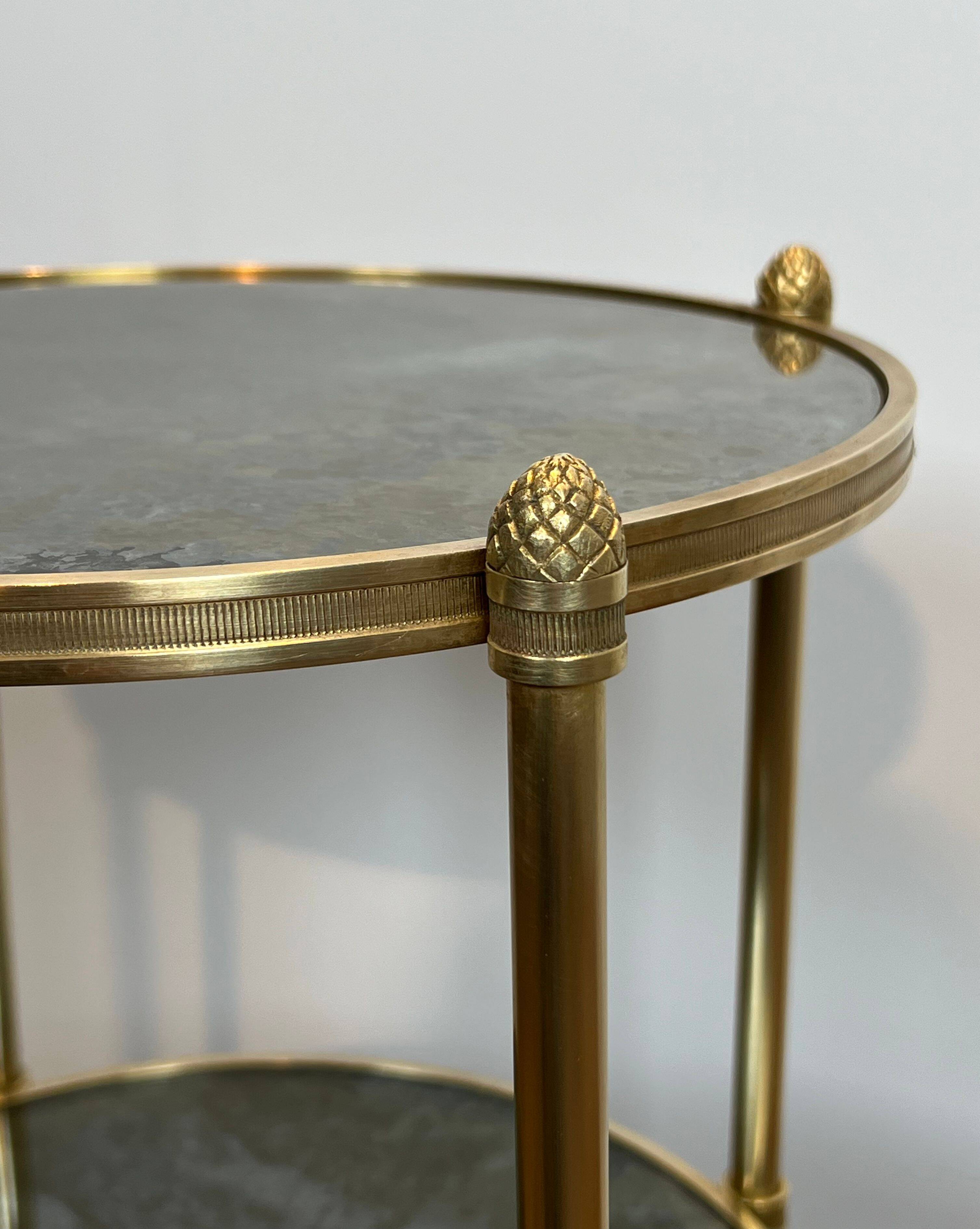 Round bronze side table with triple shelves of églomisé mirrors from Maison Baguès