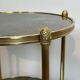 Round bronze side table with triple shelves of églomisé mirrors from Maison Baguès