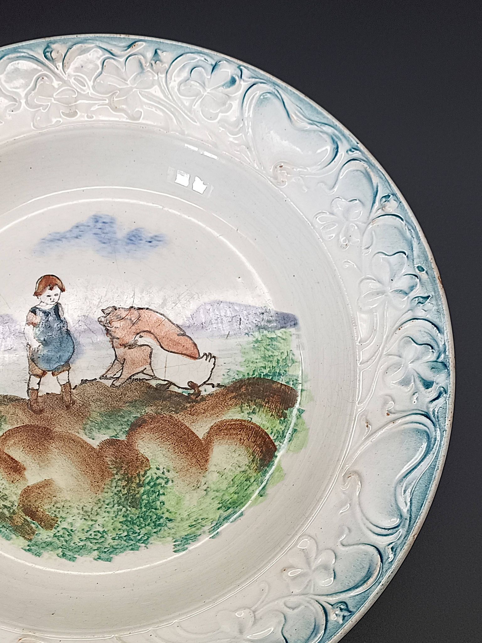 Large antique hollow dish from the 19th century, earthenware with pastoral decoration featuring a child, pig, and goose.
