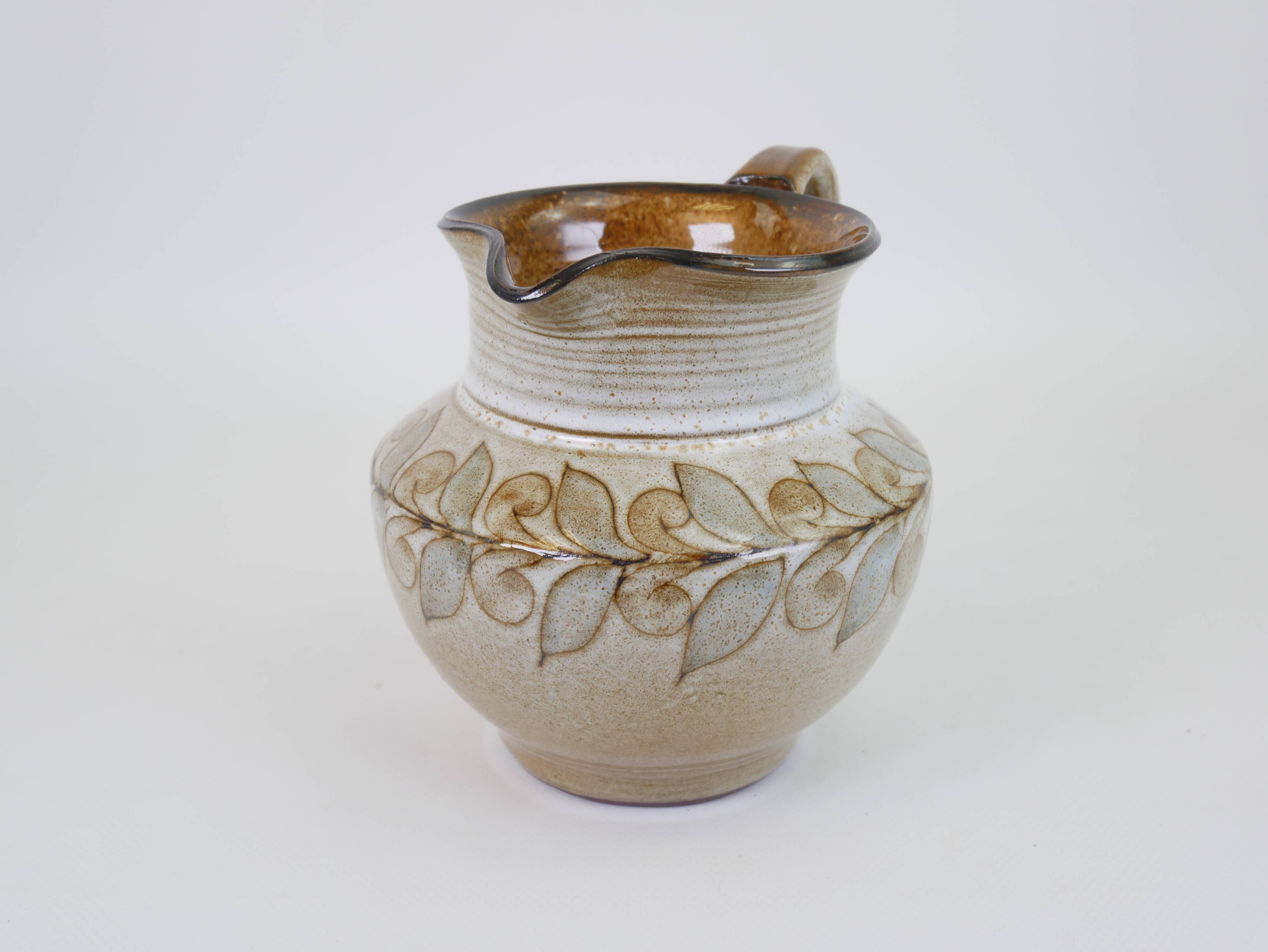 Glazed ceramic jug with plant decoration