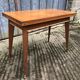 Table vintage portefeuille en chêne aux pieds compas.
