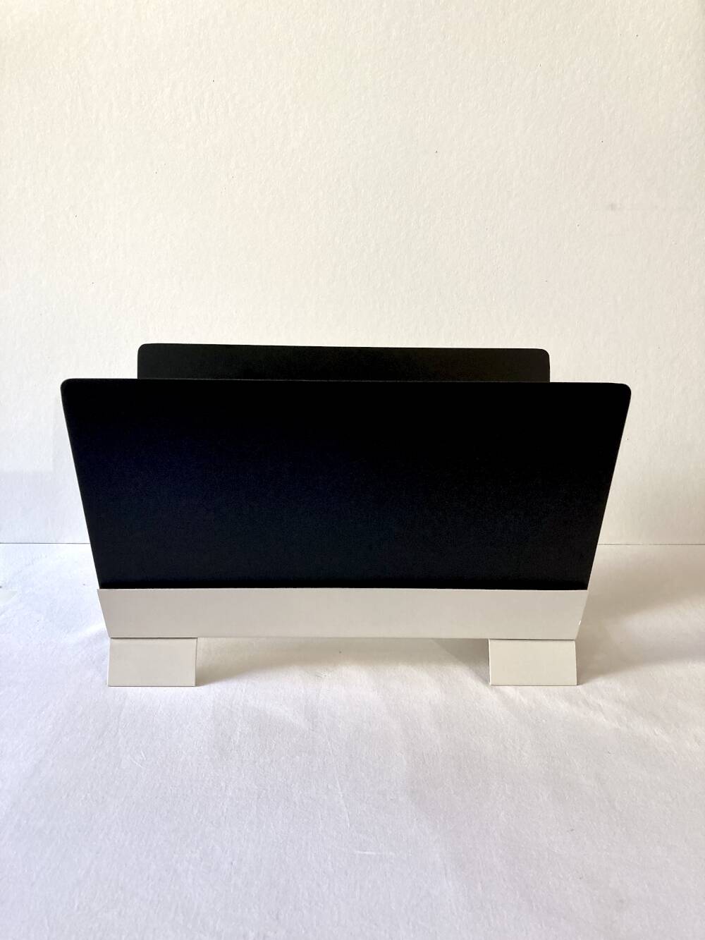 Black and cream metal magazine rack, 1950s.