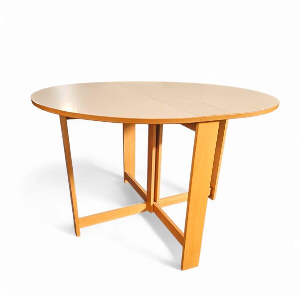 Table à manger pliante scandinave vintage avec rallonges latérales. Le plateau ovale est