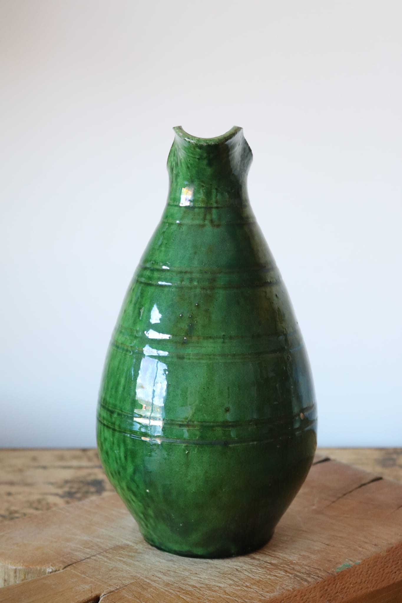 Green old pitcher in glazed terracotta