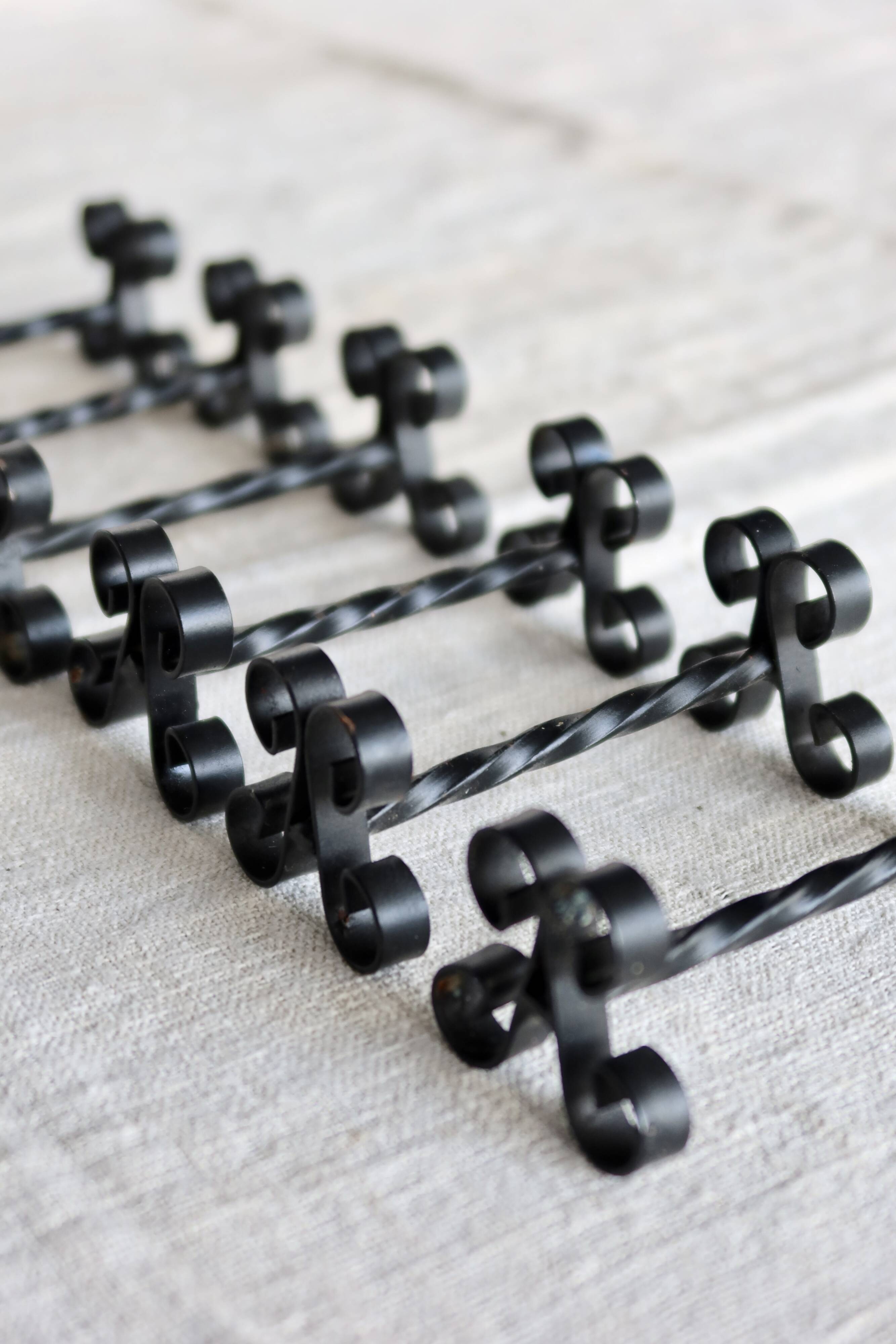 6 vintage black metal knife rests with scrollwork decoration