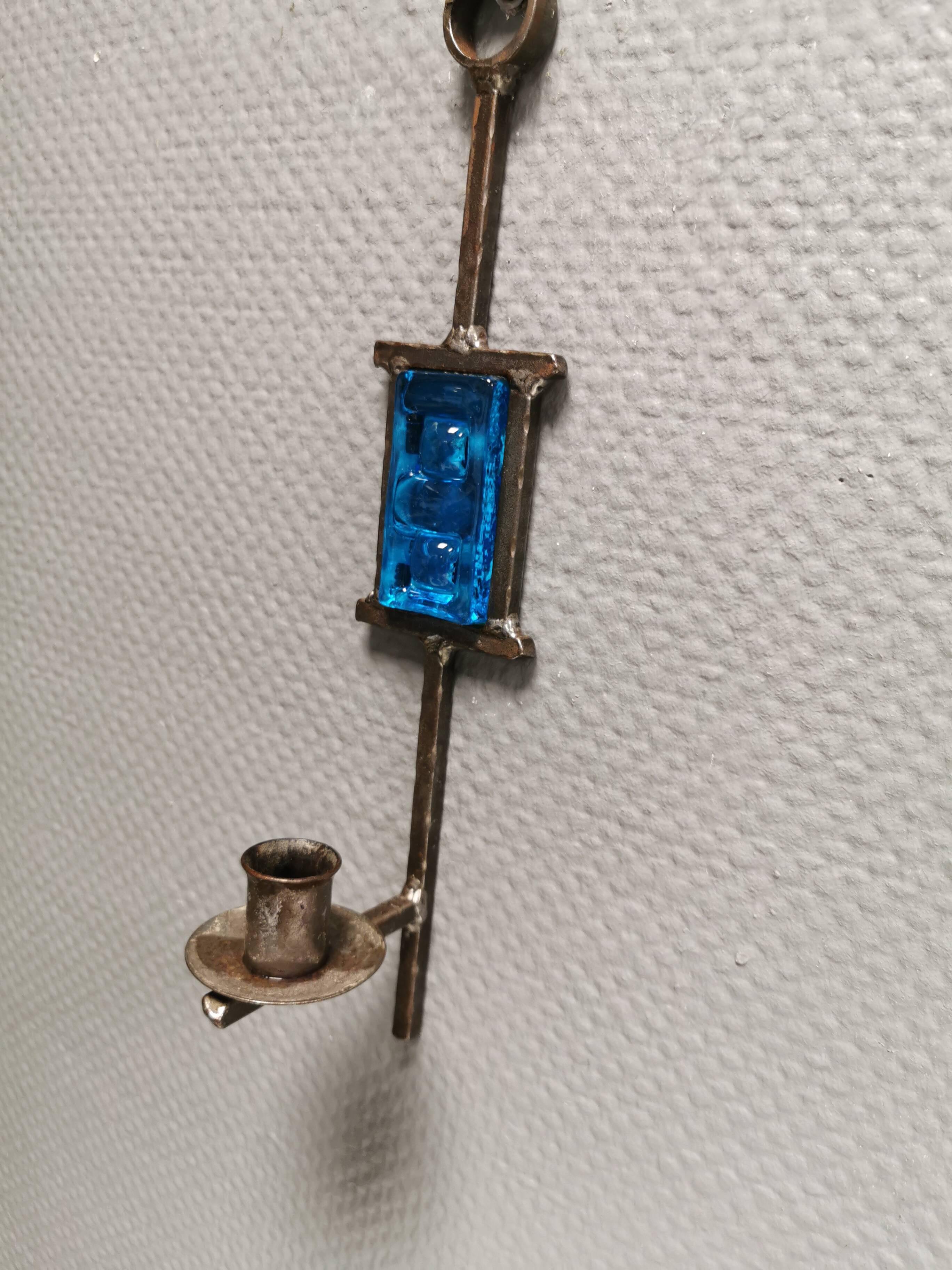 Wall-mounted candle holder in cast iron and hard pressed blue glass.
