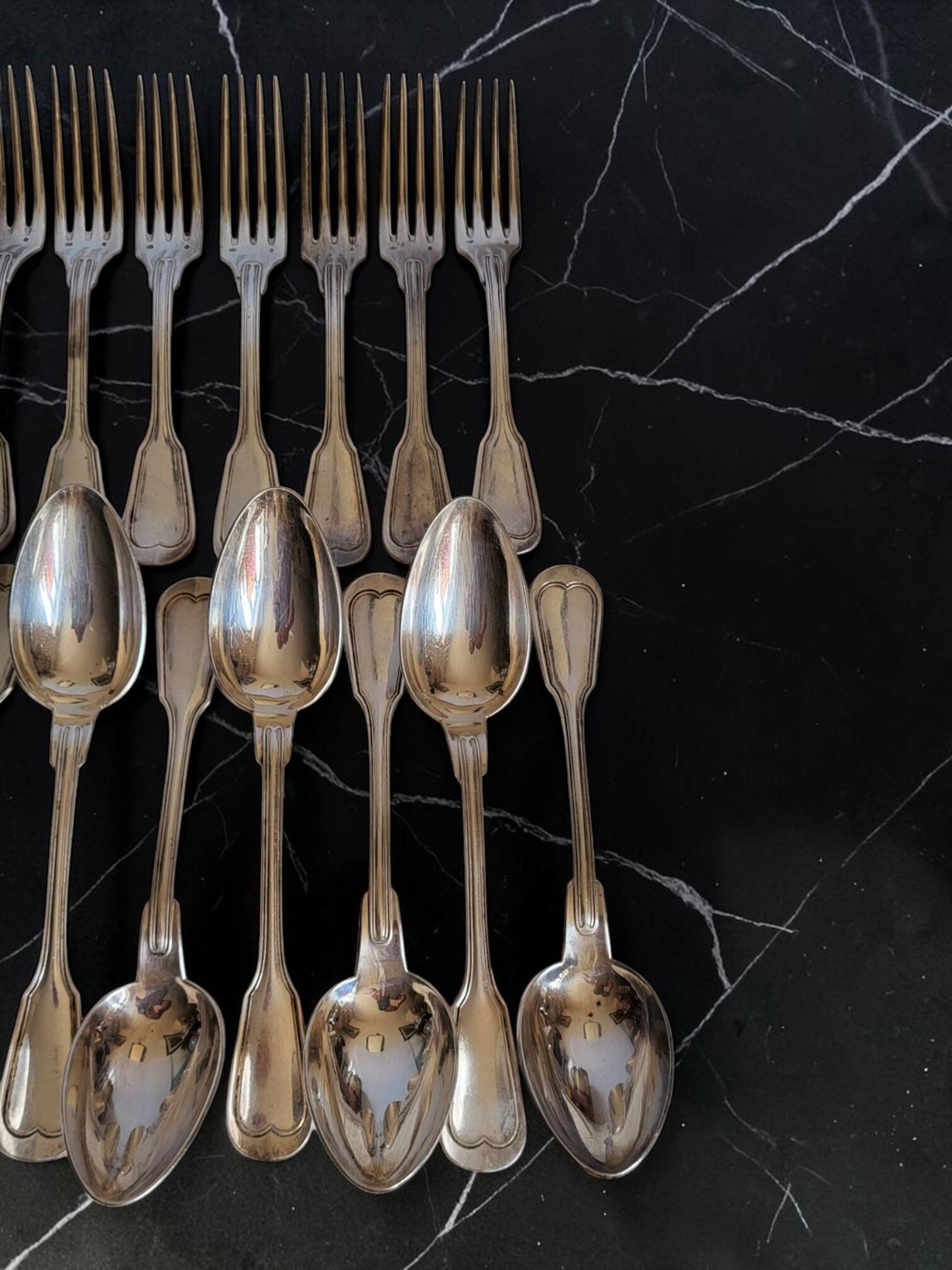 24 silver-plated metal table settings in the filet model.