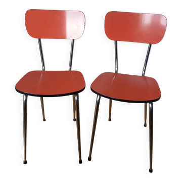 Chairs in red-orange formica and chrome metal.