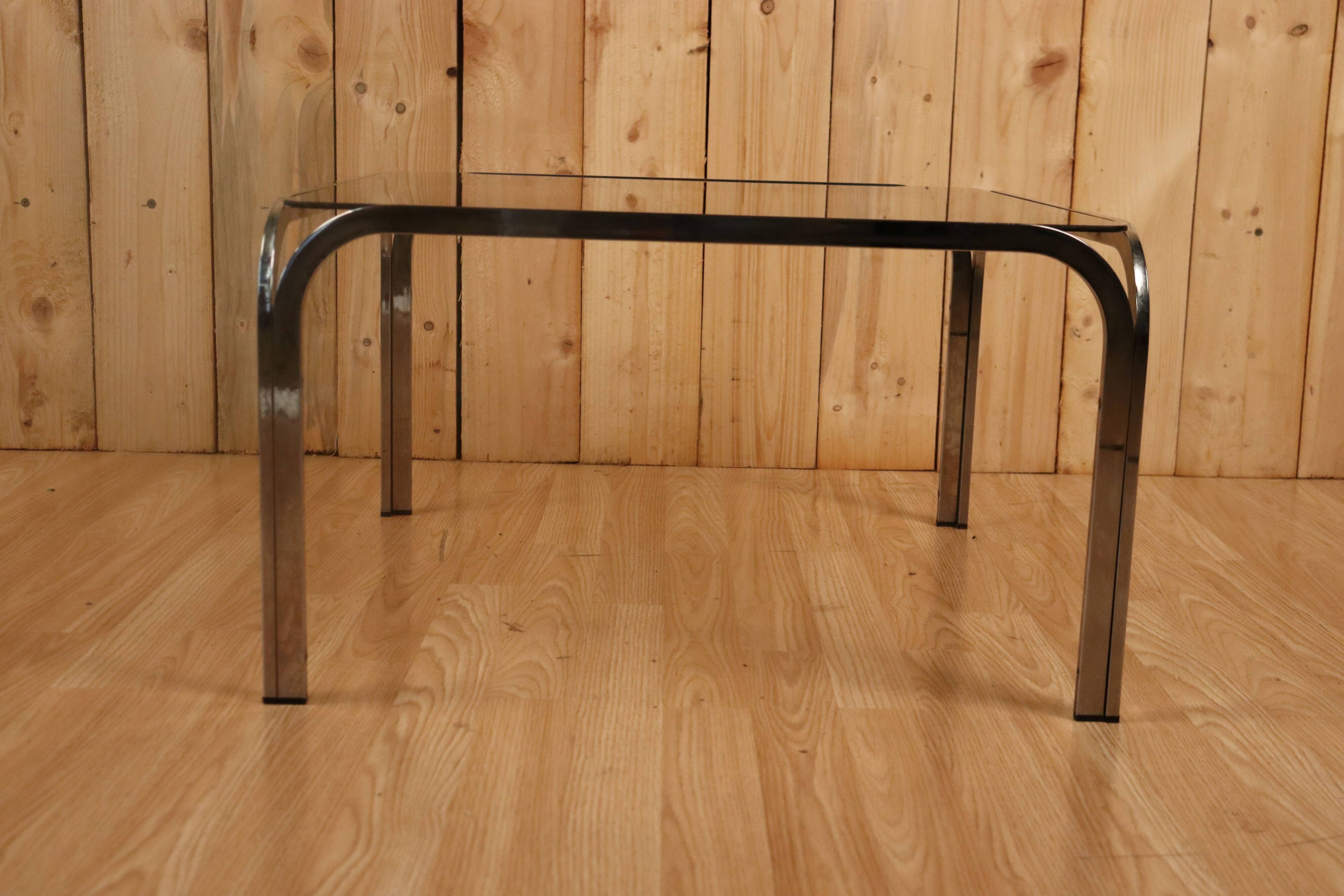 Table basse verre fumé et acier tubulaire.