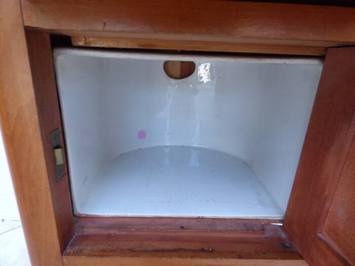 Antique bedside table with its marble top and white earthenware interior