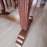 Solid wood dining table with a sculptural base.