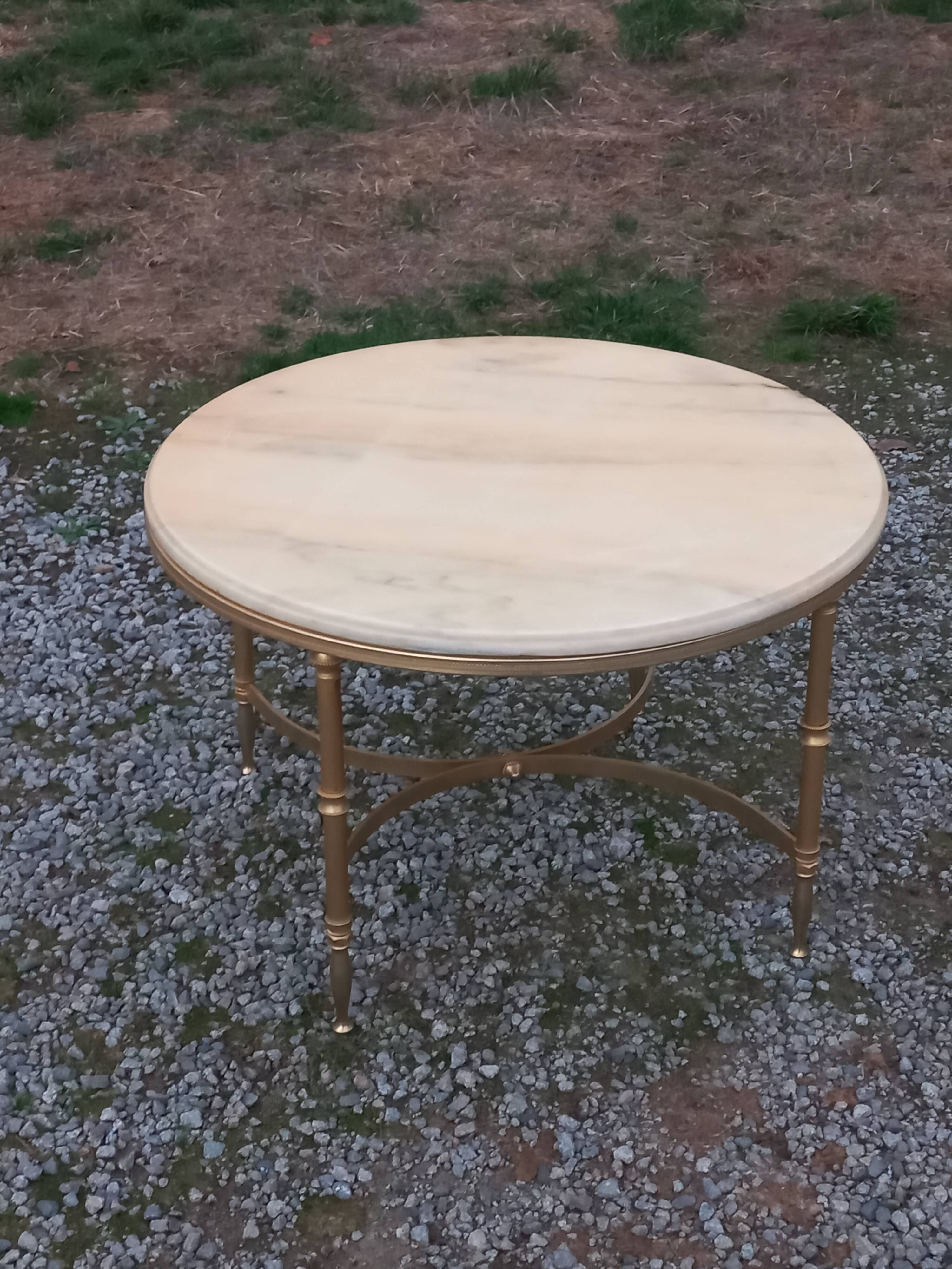 Round neoclassical coffee table with a marble top and golden metal base.