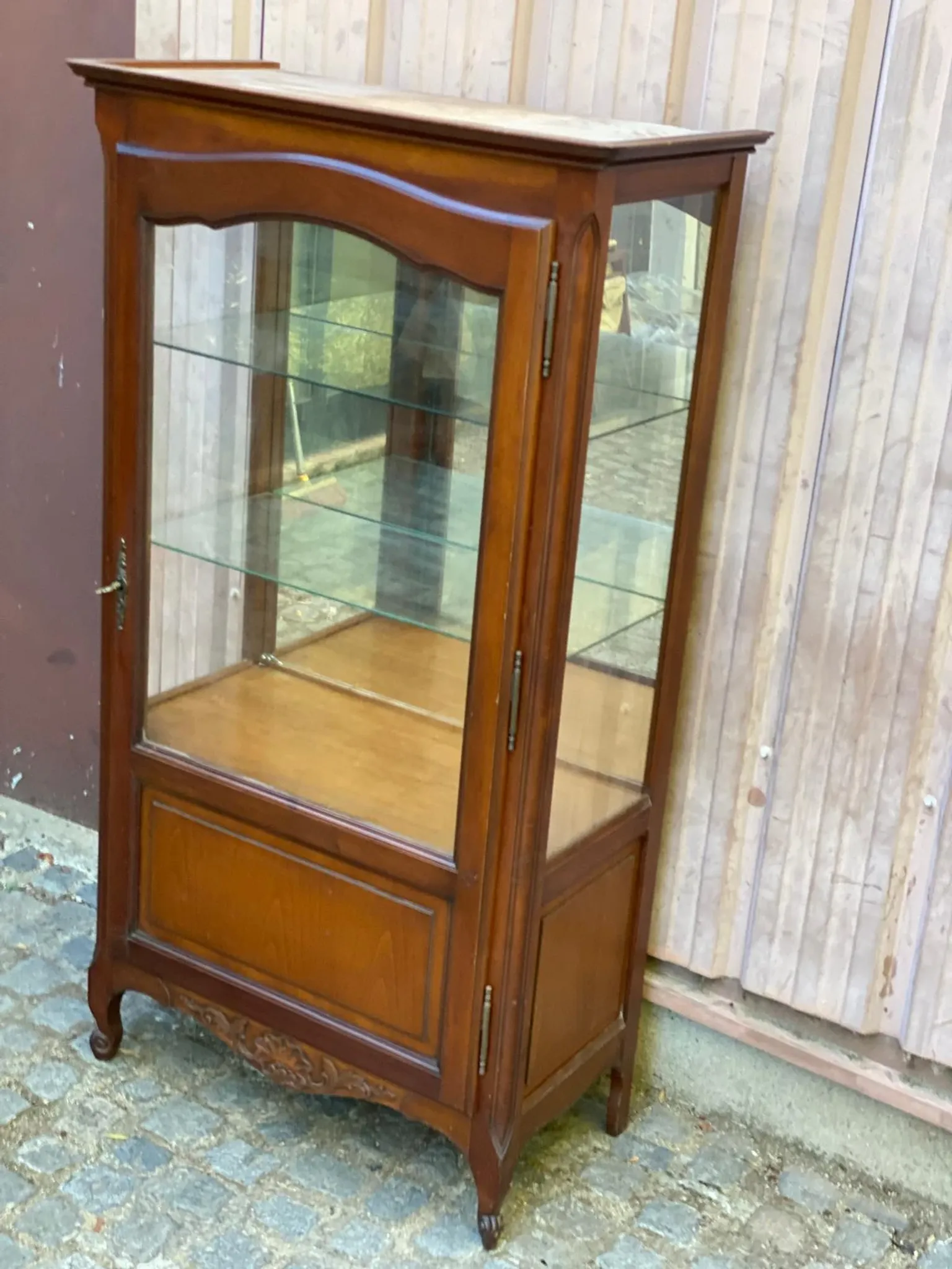 Louis XV style display cabinet in cherry wood with a mirrored back and glass shelves.
