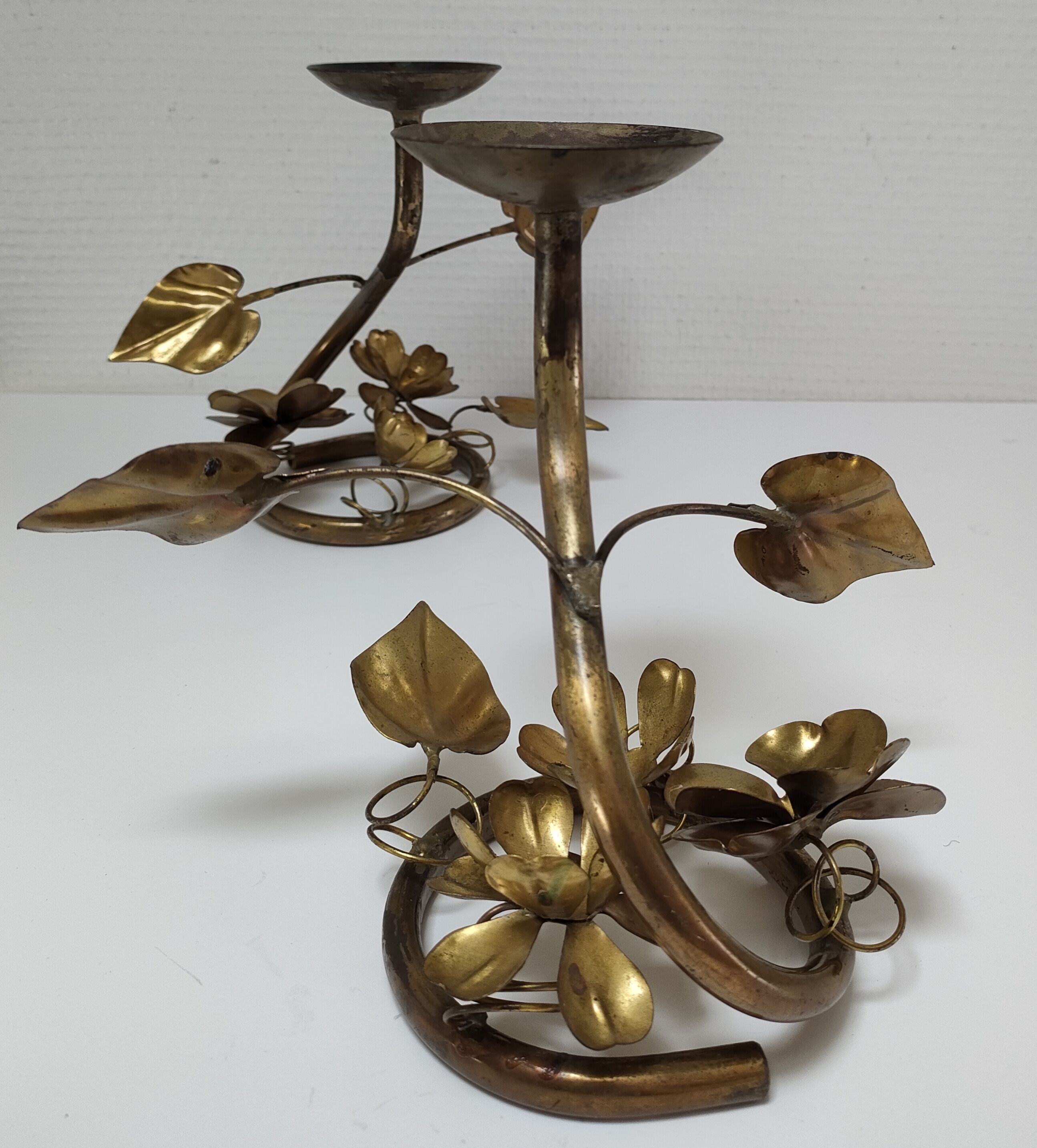 Pair of brass candle holders decorated with patinated metal flowers