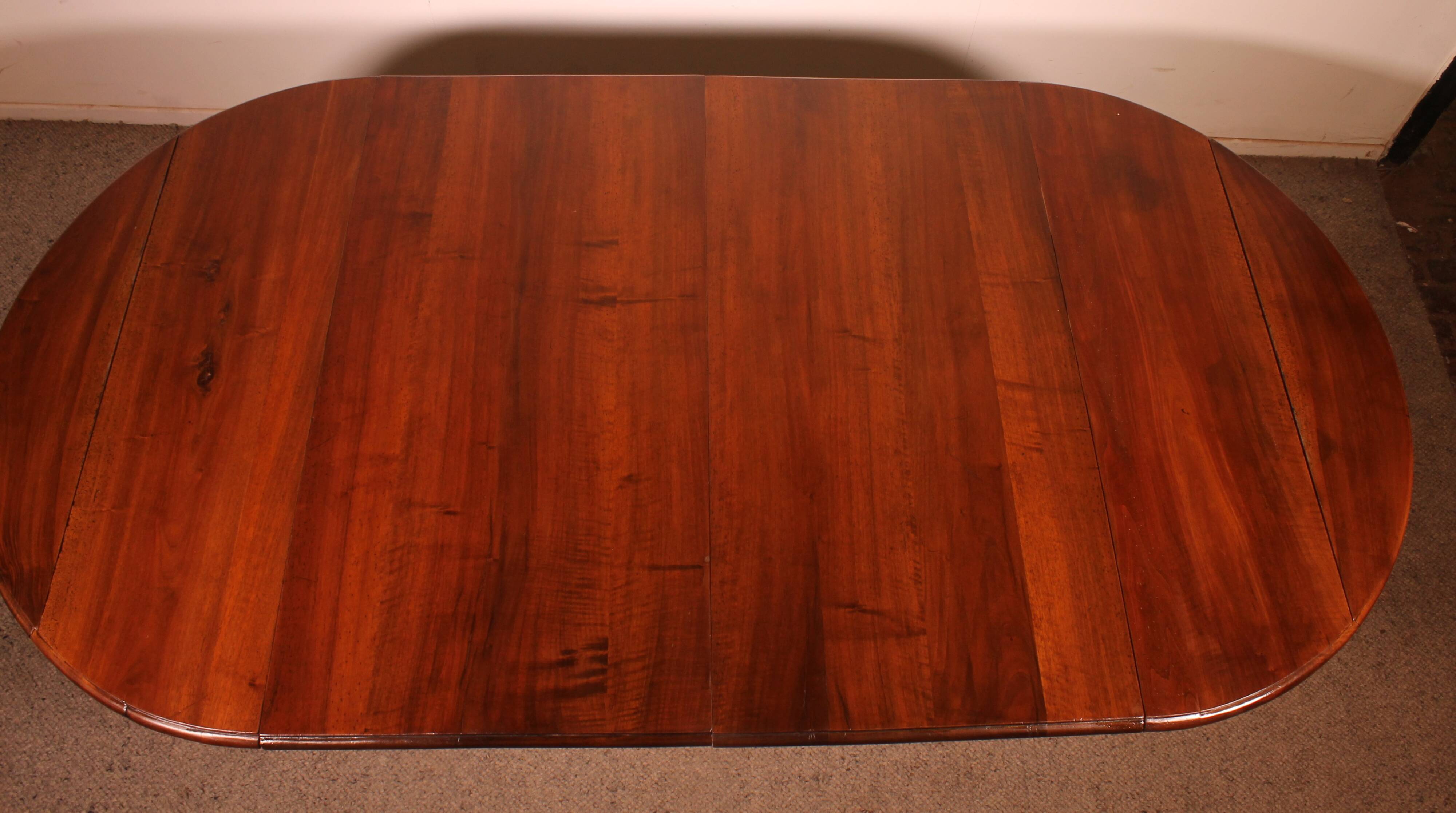 Extensible dining table from the early 19th century in walnut.