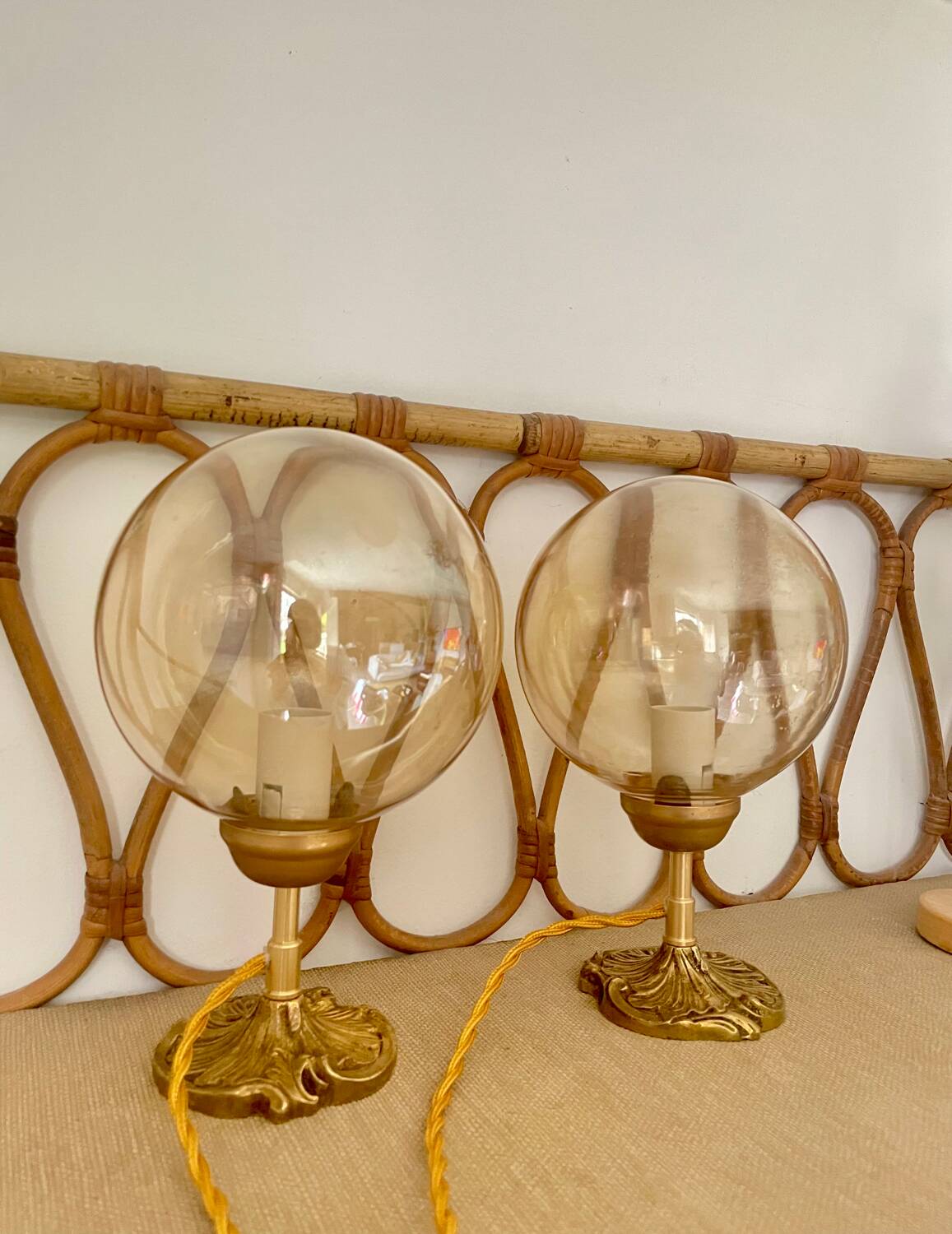 2 bedside lamps with round amber glass globes and gold metal.