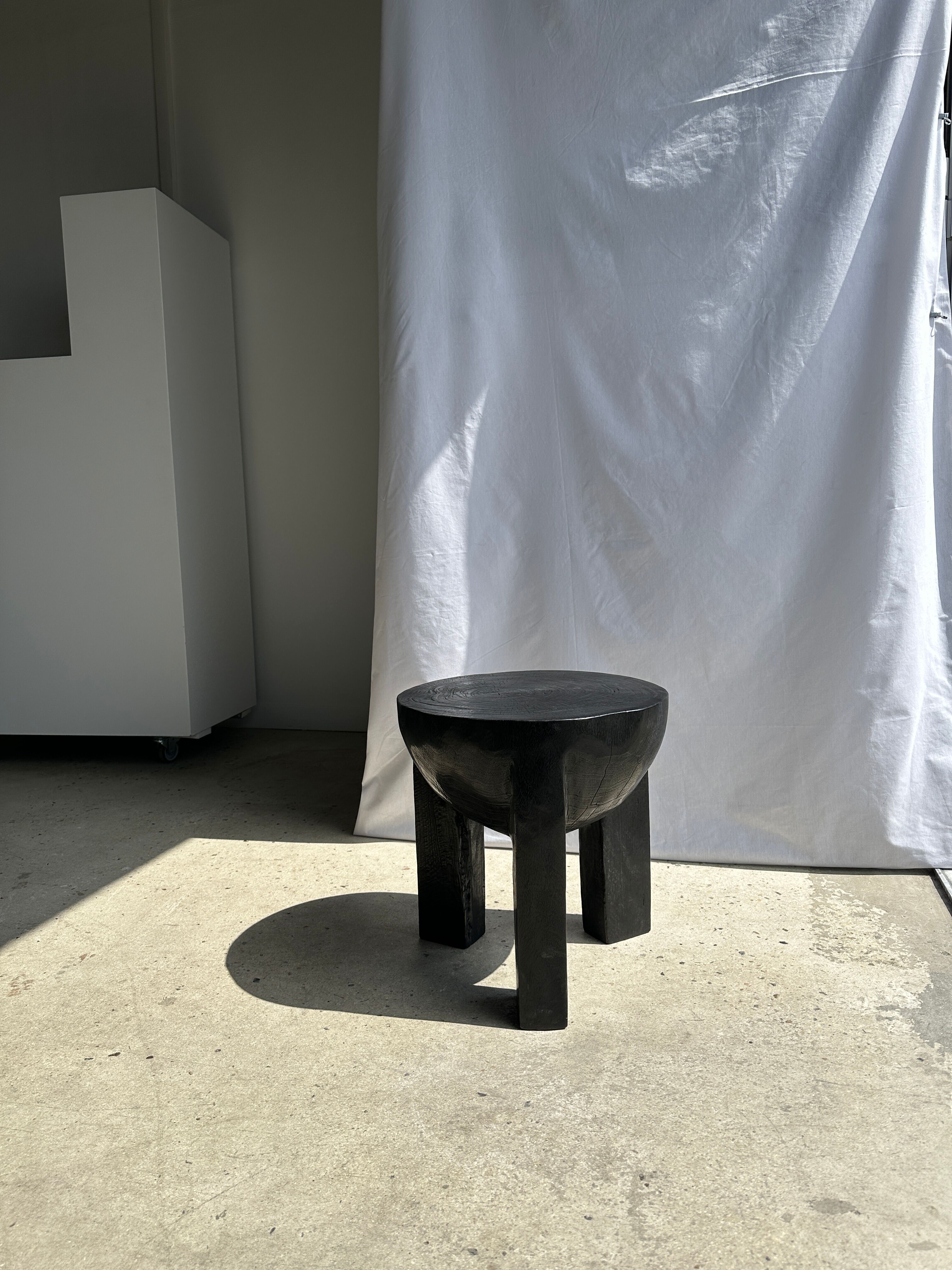 Black mango wood tripod side table with a semi-spherical top, height: 45 cm, diameter: 44 cm.