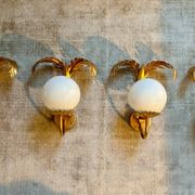 Pair of palm leaf wall lights in Hollywood Regency style with opaque globes by Hans Kögl, Germany, 1970s.