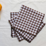Nappe volantée en lin blanche et serviettes vichy marron