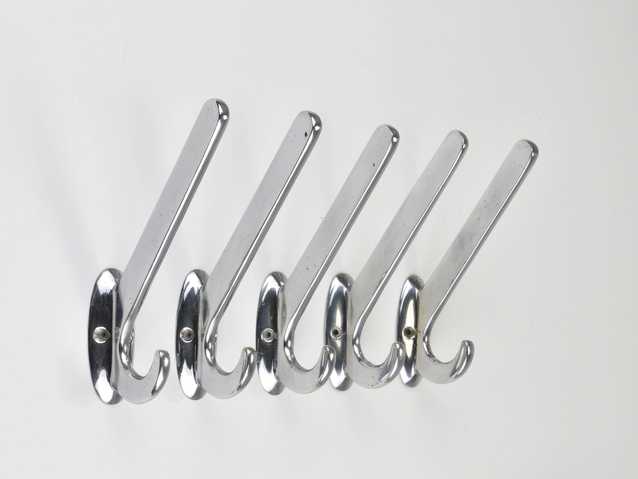 Up to 5 large Art Deco Bauhaus wall hooks in nickel and brass, Vienna, 1930s.