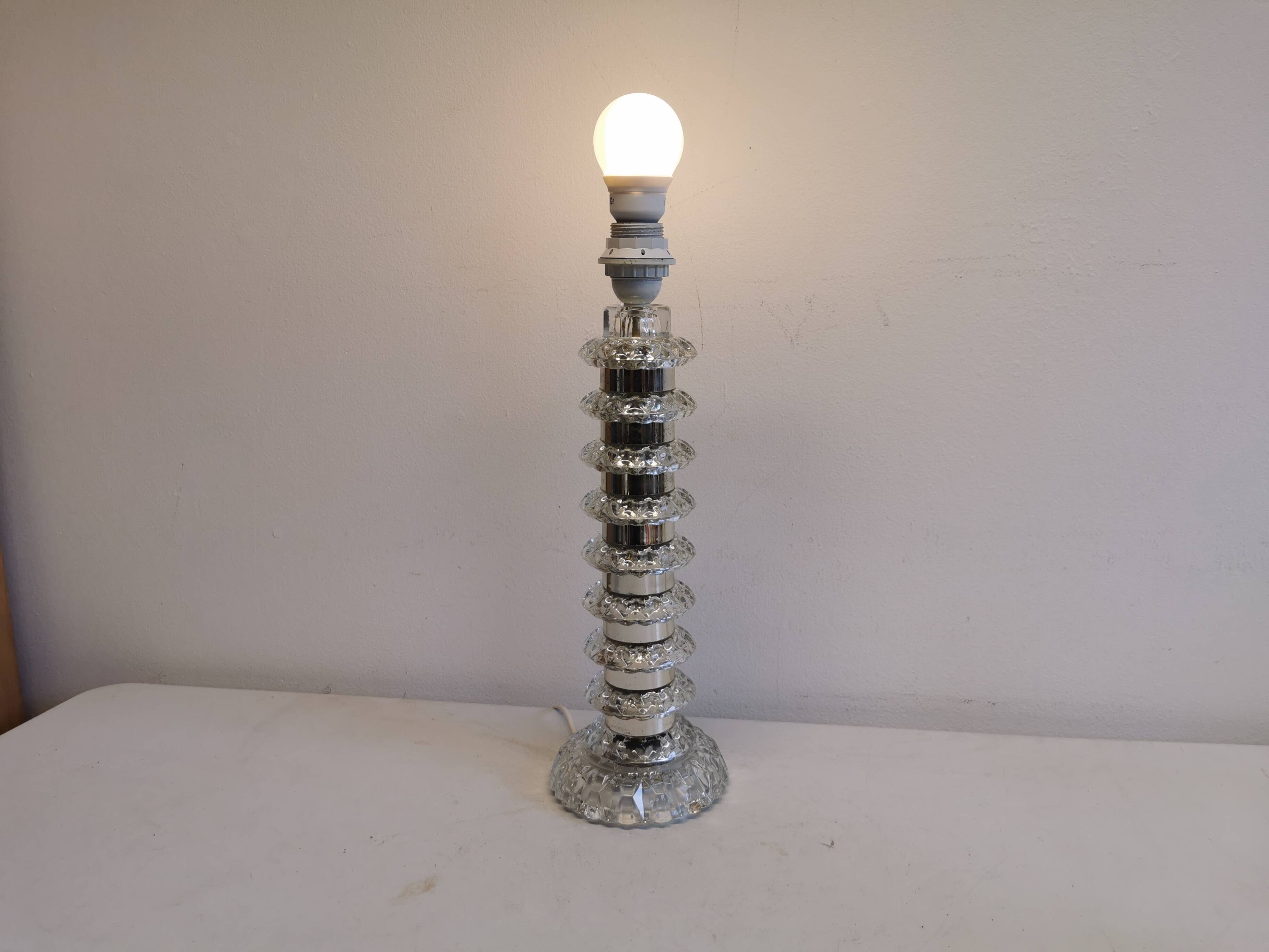 Table lamp made of transparent crystal glass and silver colored spacers.