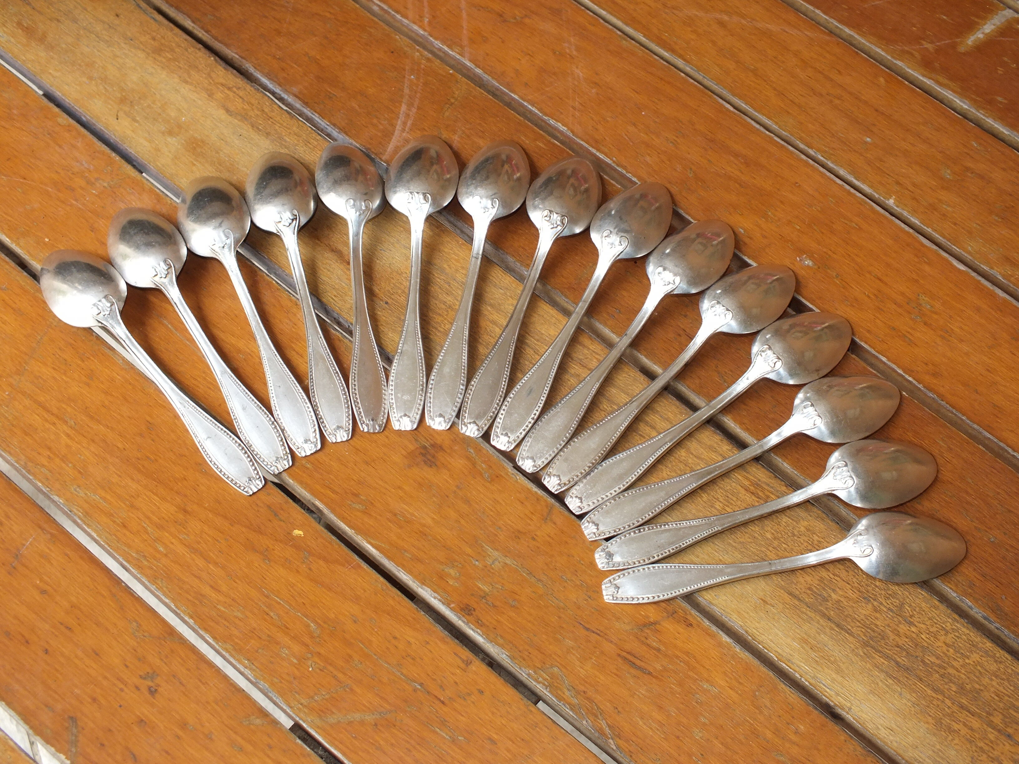 15 small silver metal spoons with rows of beads
