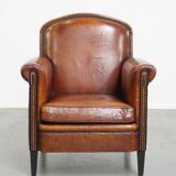 Sheepskin leather armchair in a cognac color with black piping
