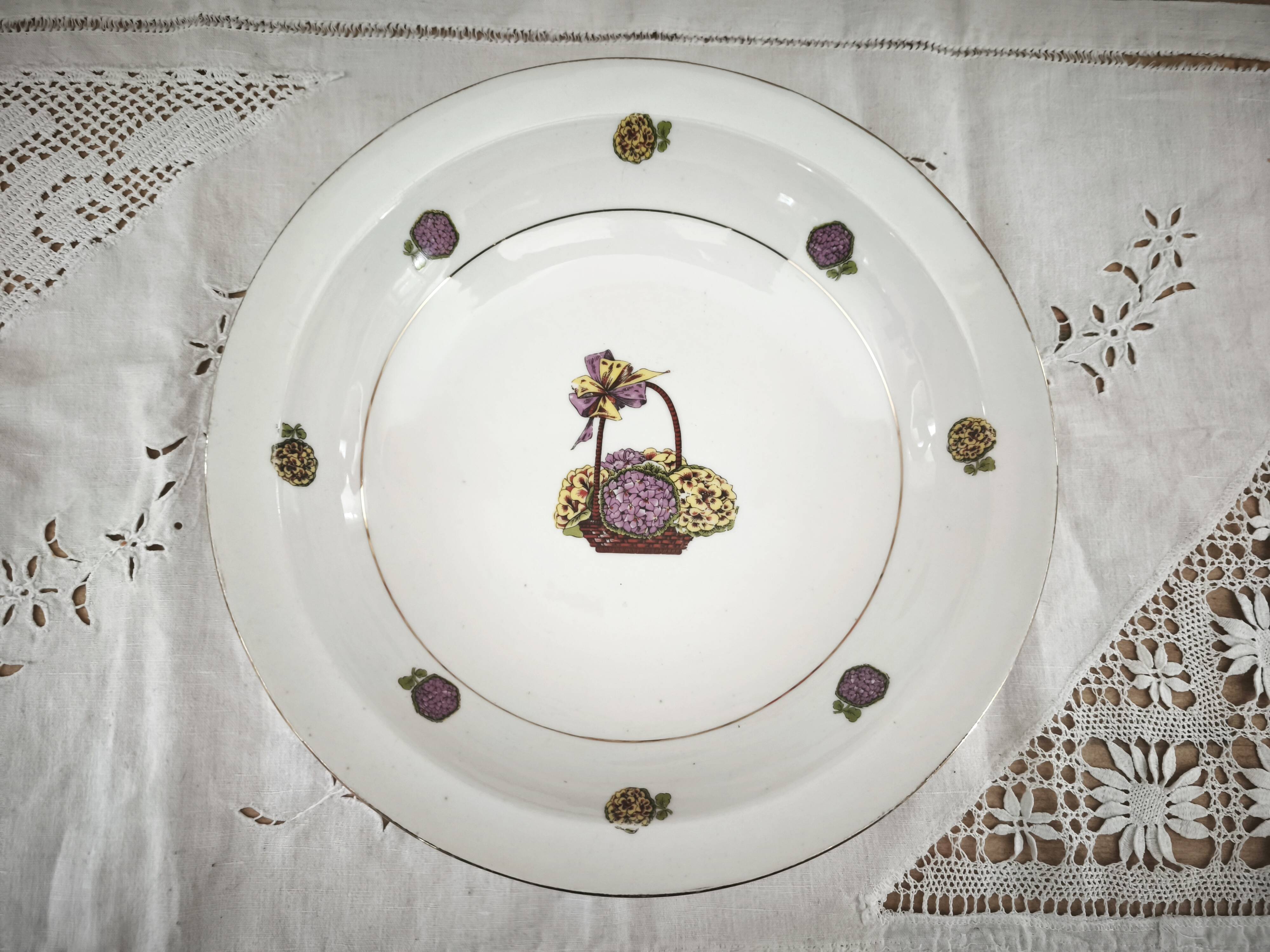 Shallow round plate in Limoges porcelain with a hydrangea basket design.