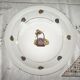 Shallow round plate in Limoges porcelain with a hydrangea basket design.