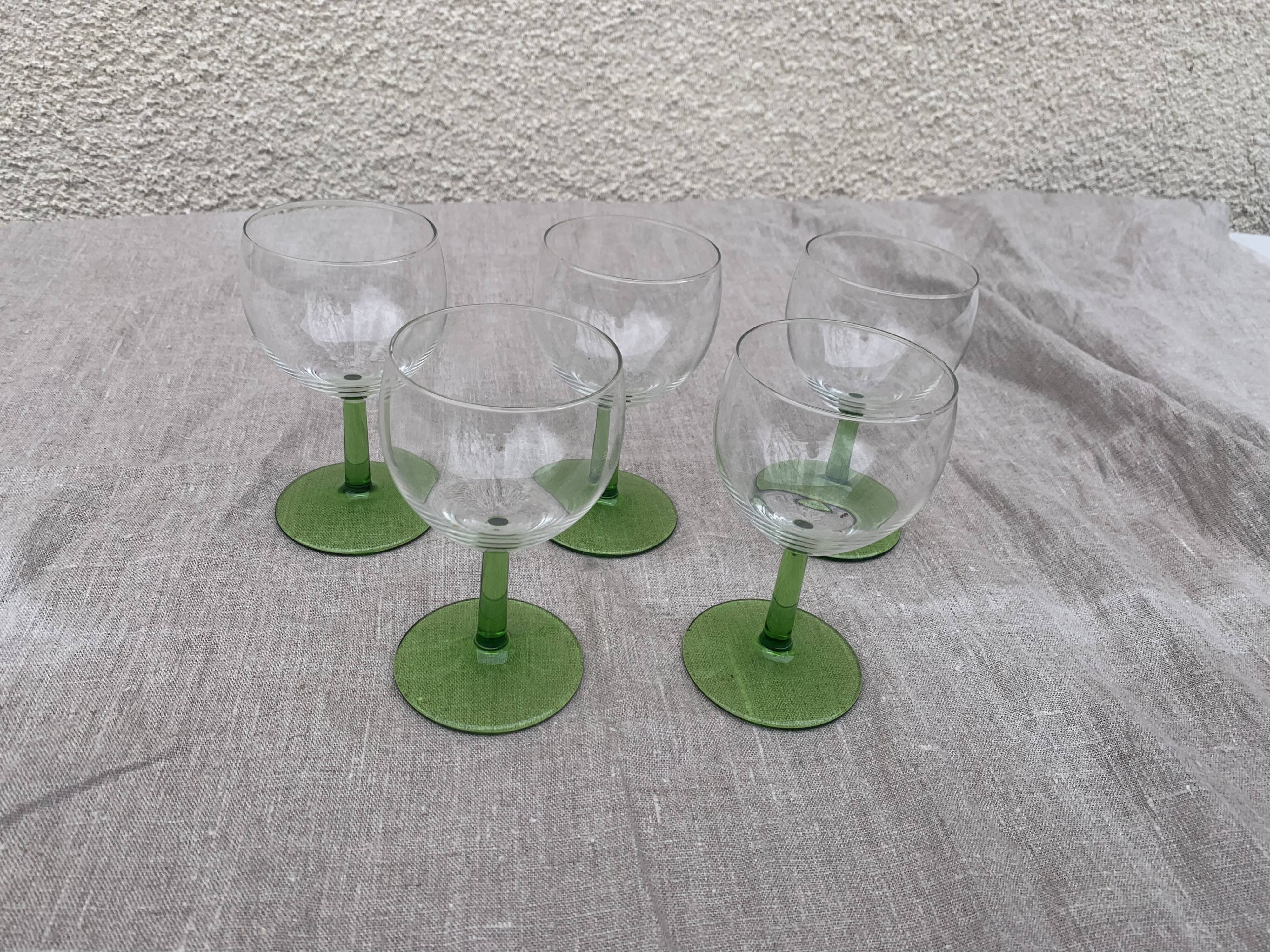 5 transparent glass glasses and green glass vase go