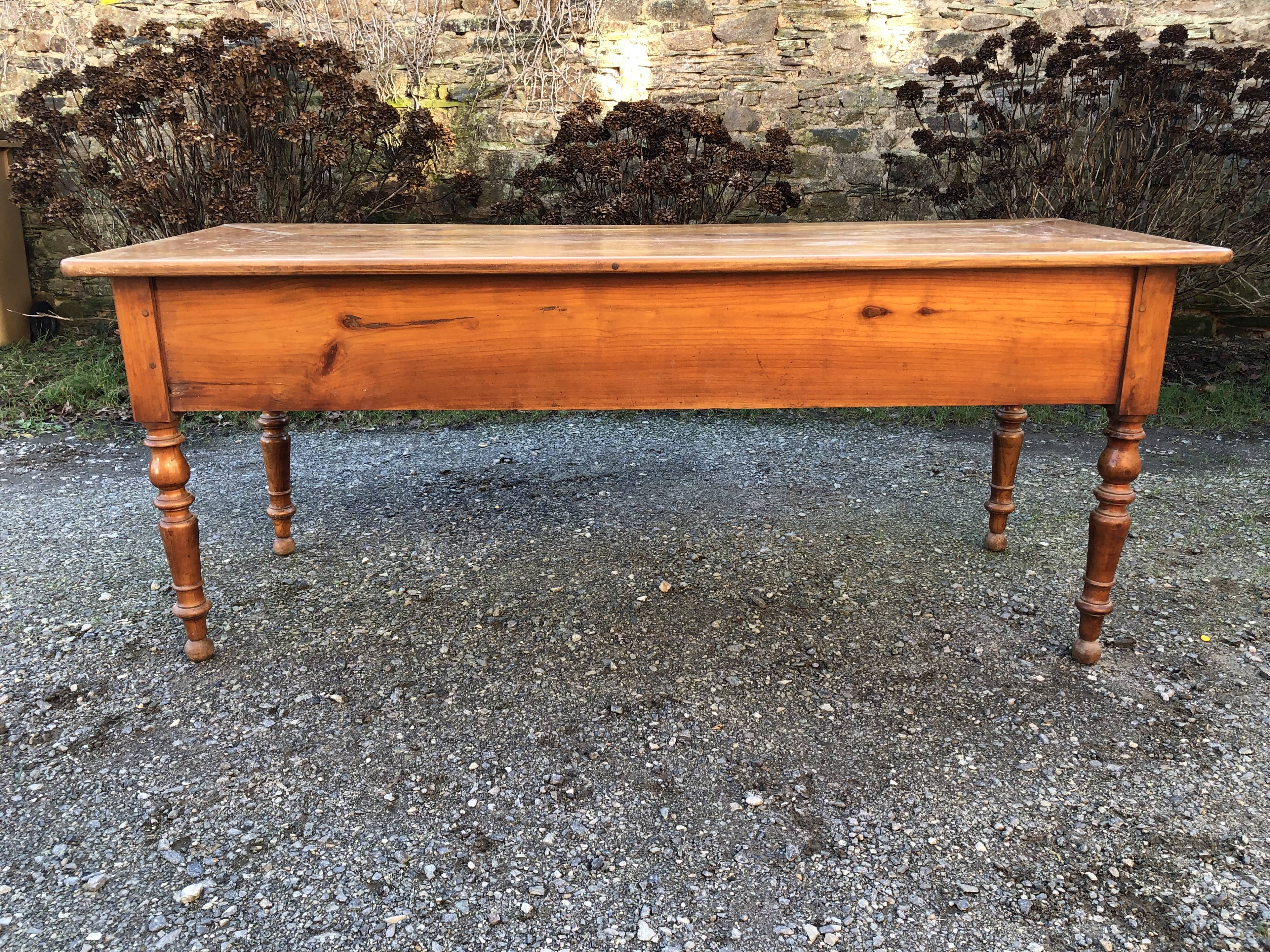 Antique cherry farmhouse table with turned legs and 2 drawers.
