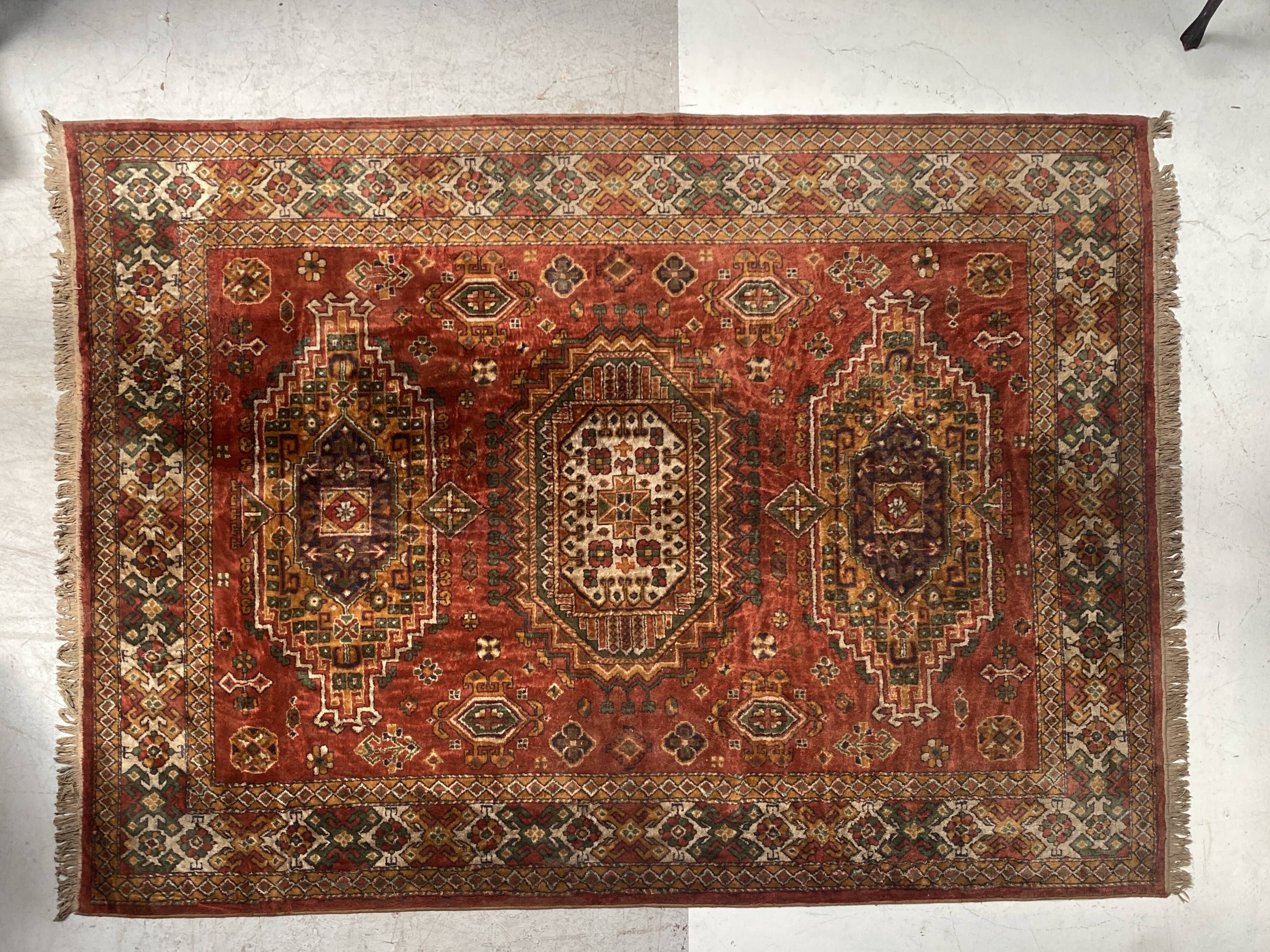 Antique wool rugs with designs on a red background, 20th century.