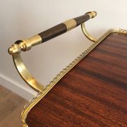 Mahogany and brass rolling table in the style of Maison Jansen.