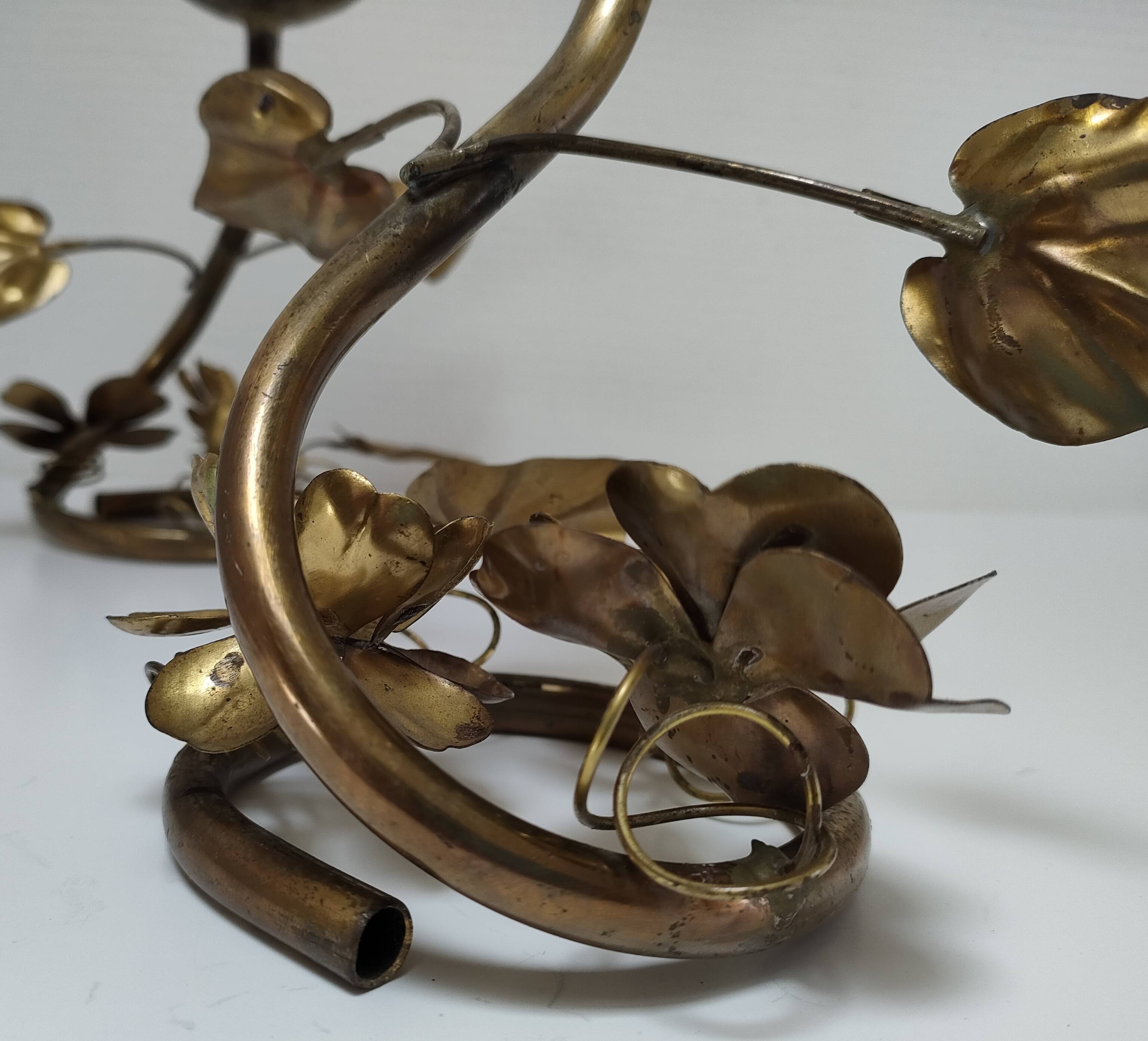 Pair of brass candle holders decorated with patinated metal flowers