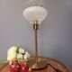 Table lamp with gold metal base and vintage white glass lampshade