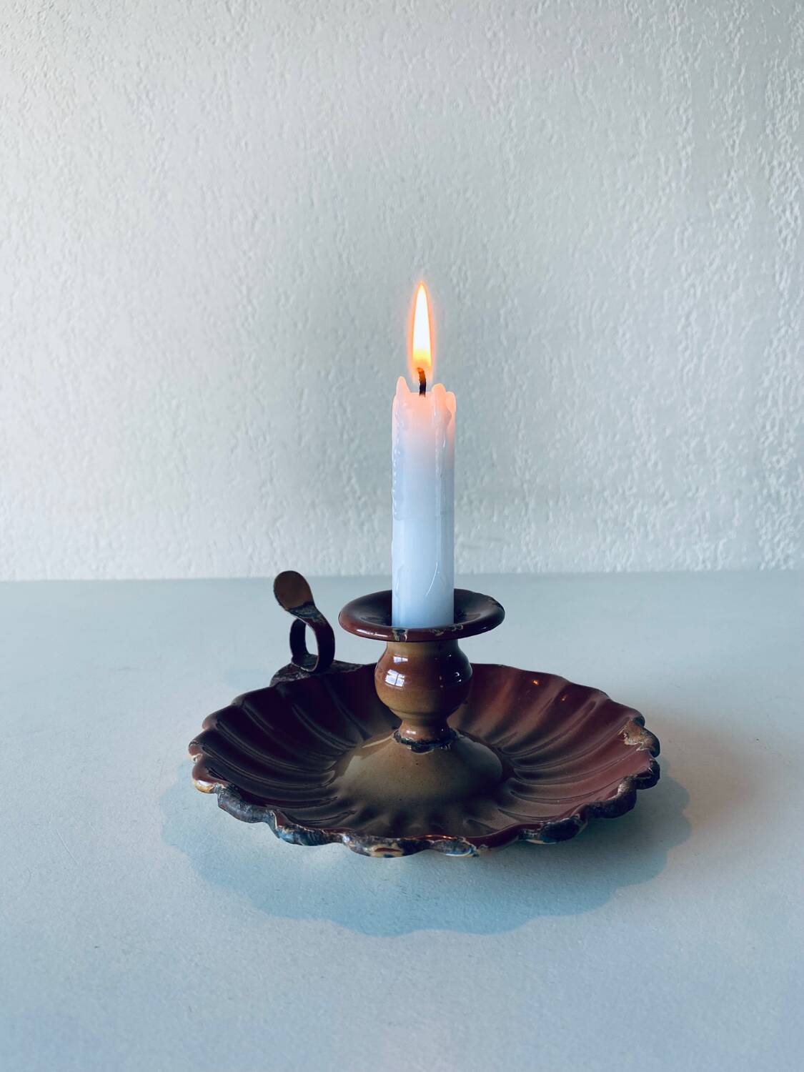 Old candle holder in brown enameled metal