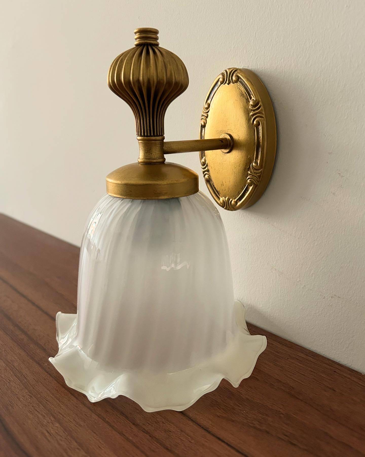 Gold wall sconce with ecru globe