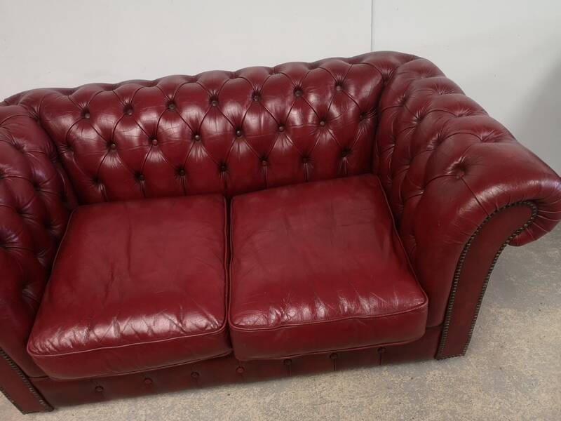 Red two-seater chesterfield sofa