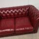 Red two-seater chesterfield sofa