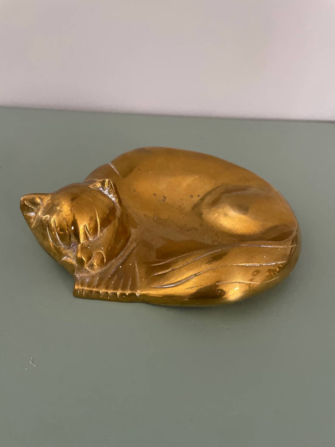 Cat-shaped catchall that looks like it's sleeping.