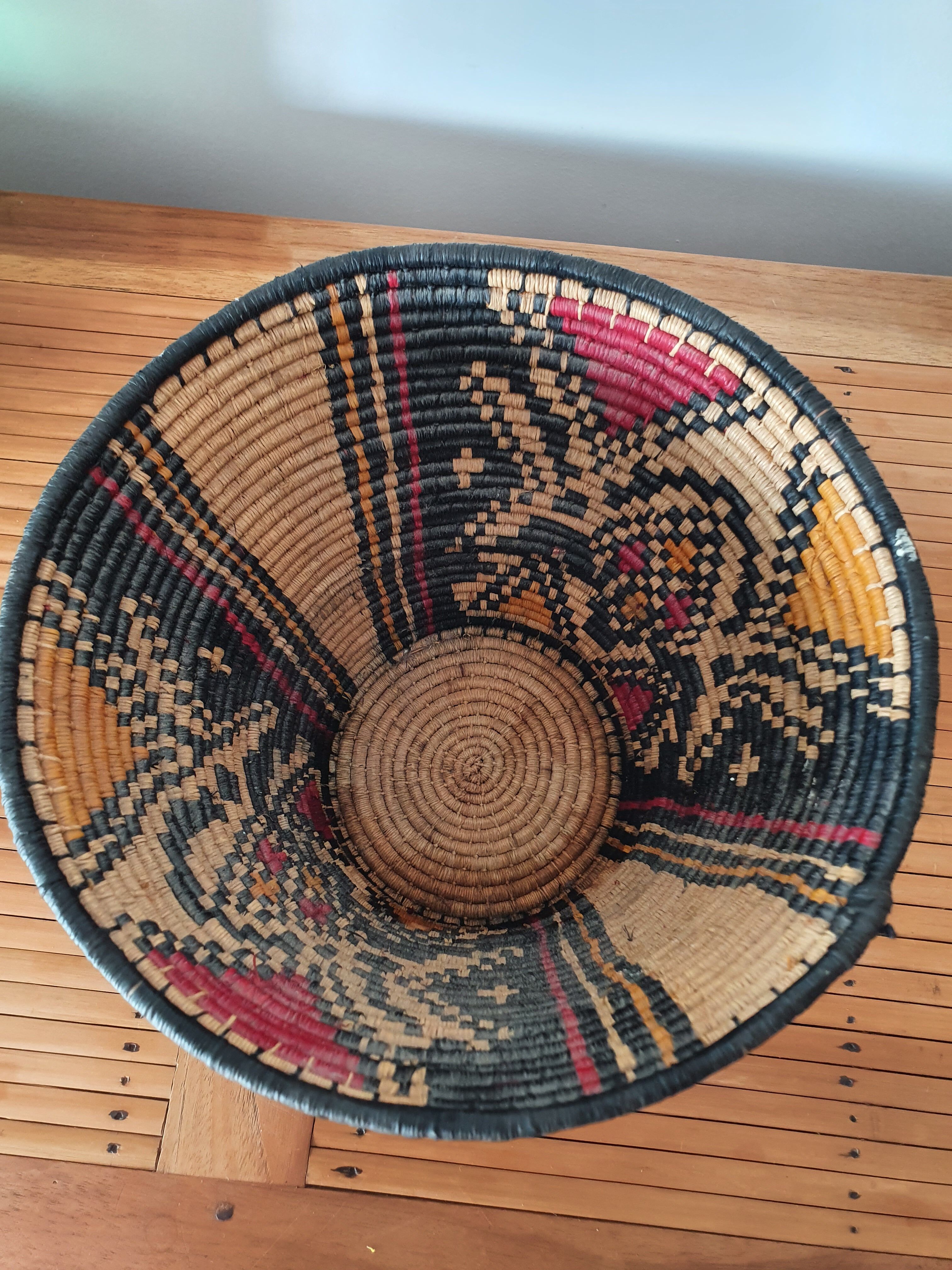 Ethnic basket in multicolored braided straw