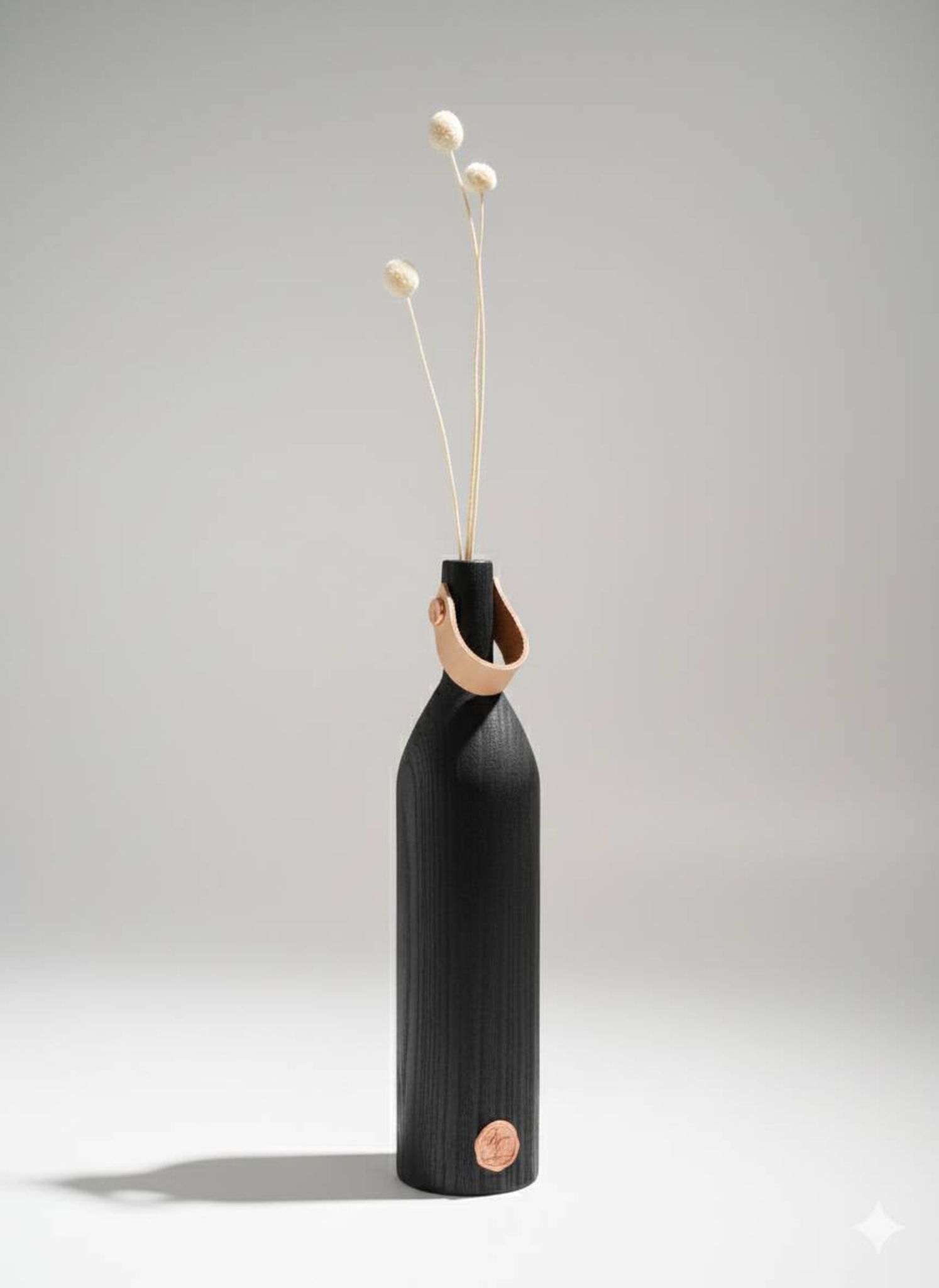 Burnt wood vase for dried flowers, with a leather and brass handle.