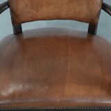 Elegant antique sheepskin leather desk chair with a heavy wooden frame