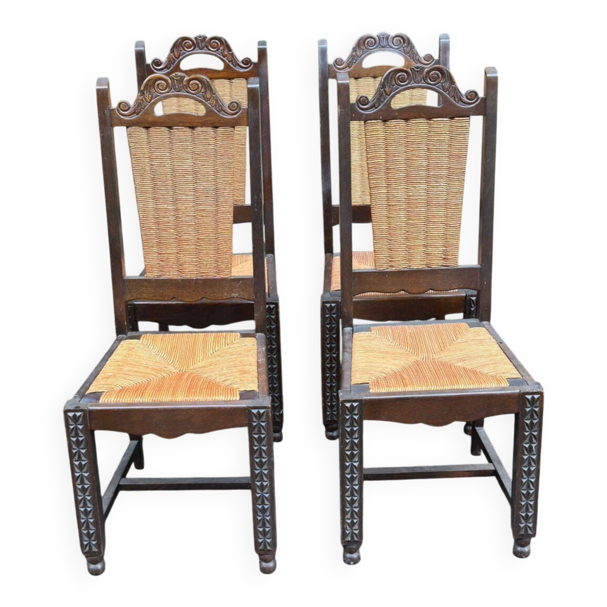 4 Basque solid wood dining chairs with carved straw seats.