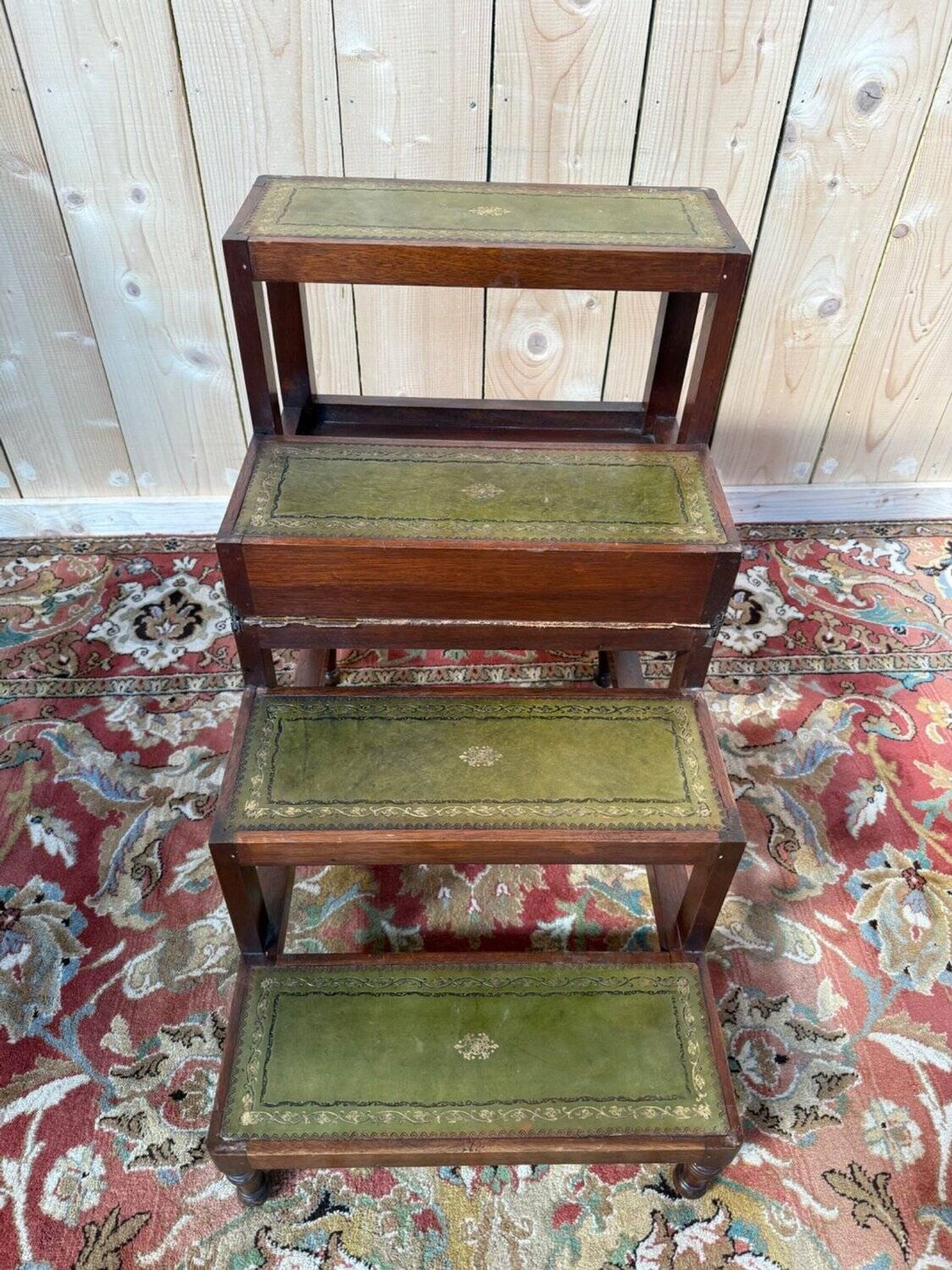 19th-century English library staircase, green leather with gold detailing.
