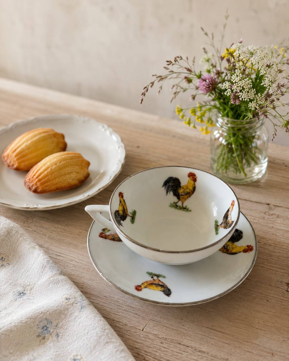 Cup and saucer in porcelain decorated with roosters and hens.