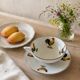 Cup and saucer in porcelain decorated with roosters and hens.