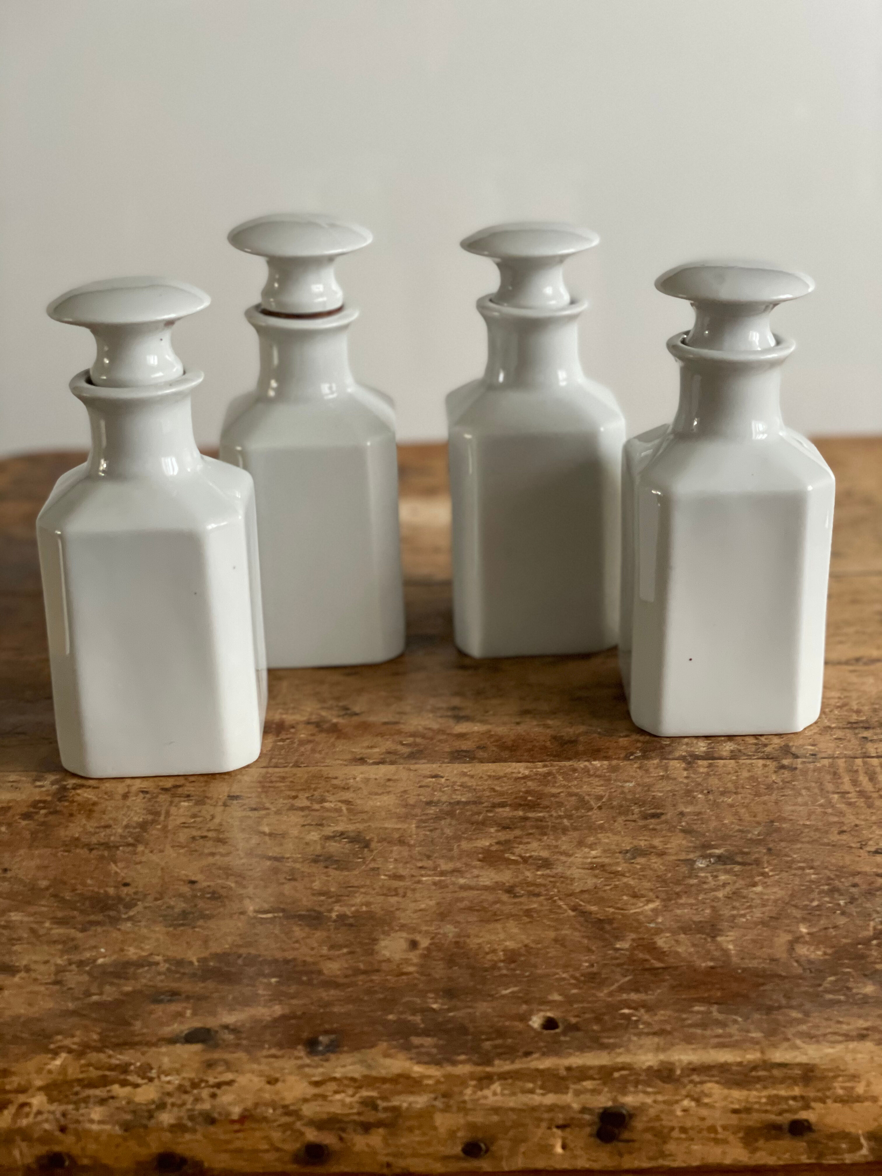 4 old white pharmacy style bottles